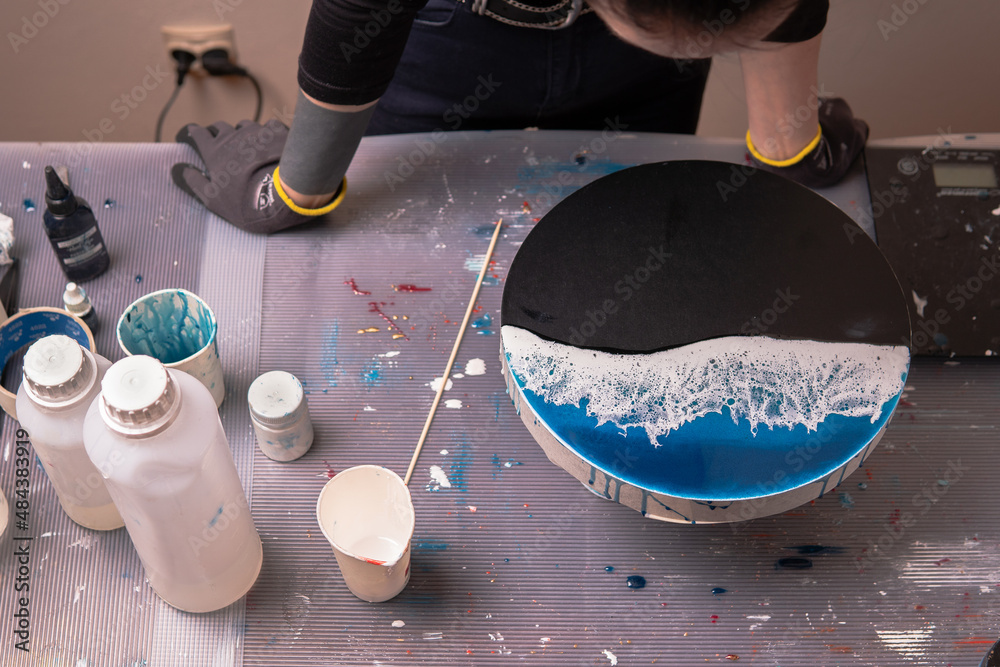 Epoxy resin. The creative hobby process of creating an artist's painting of  a liquid resin imitation of the sea on a slate stone board Stock Photo |  Adobe Stock