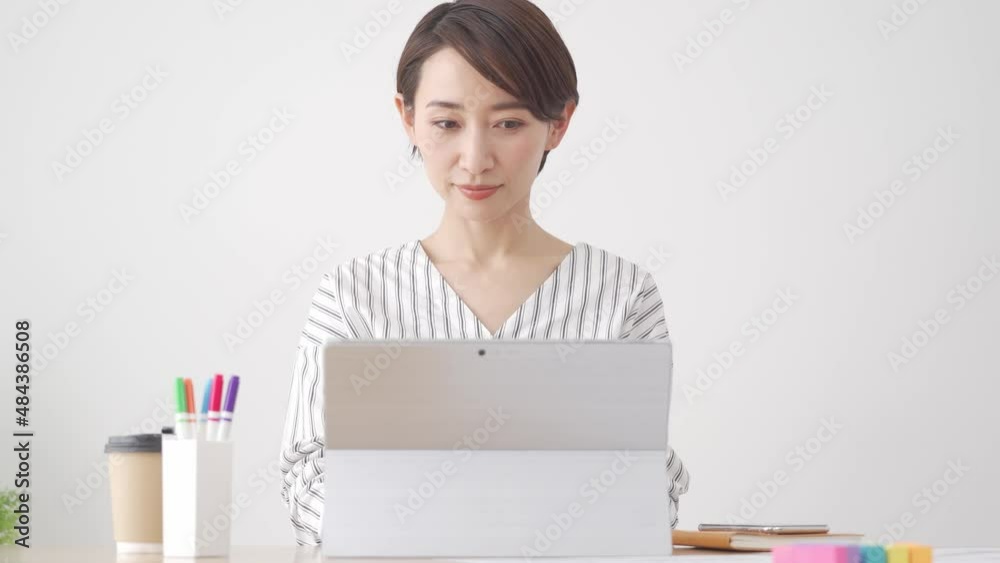 パソコンと資料を見る日本人女性
