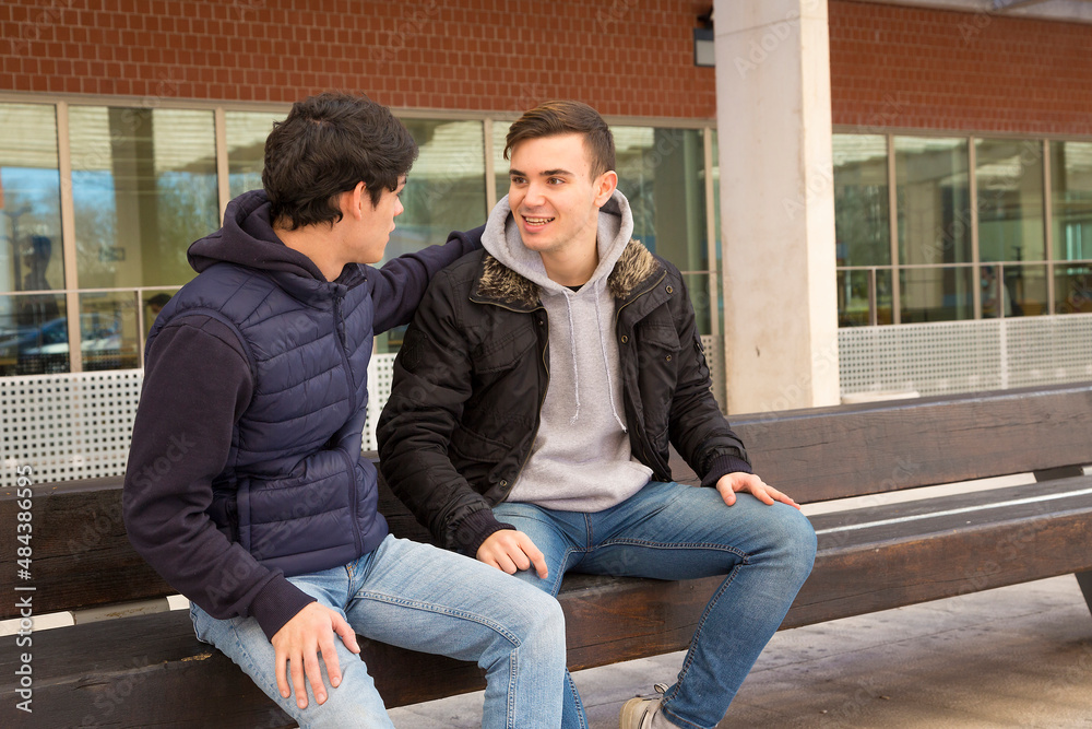 couple of boys sitting on a bench talking couple of boys sitting on a bench talking