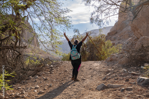 Woman posing with her back to the camera on a valley