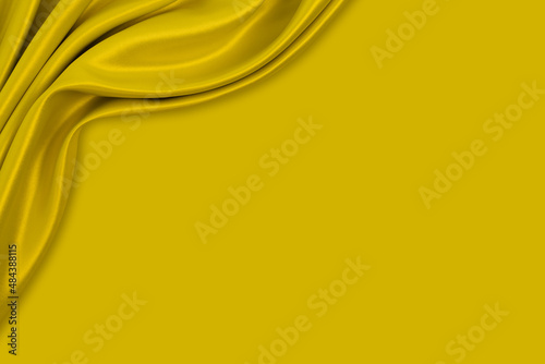 Beautiful smooth elegant wavy golden mustard yellow satin silk with yellow monochrome background design. Luxury cloth fabric texture.