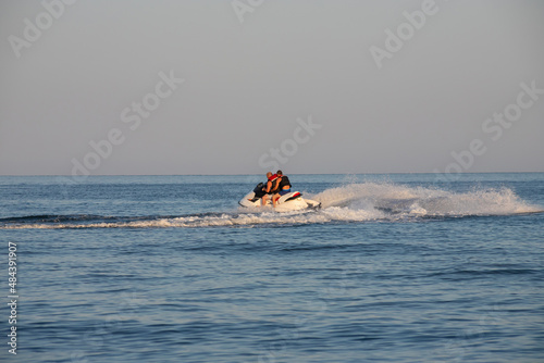 Teen age boy skiing on water scooter. Young man on personal watercraft in tropical sea. Active summer vacation for school child. Sport and ocean activity on beach holiday