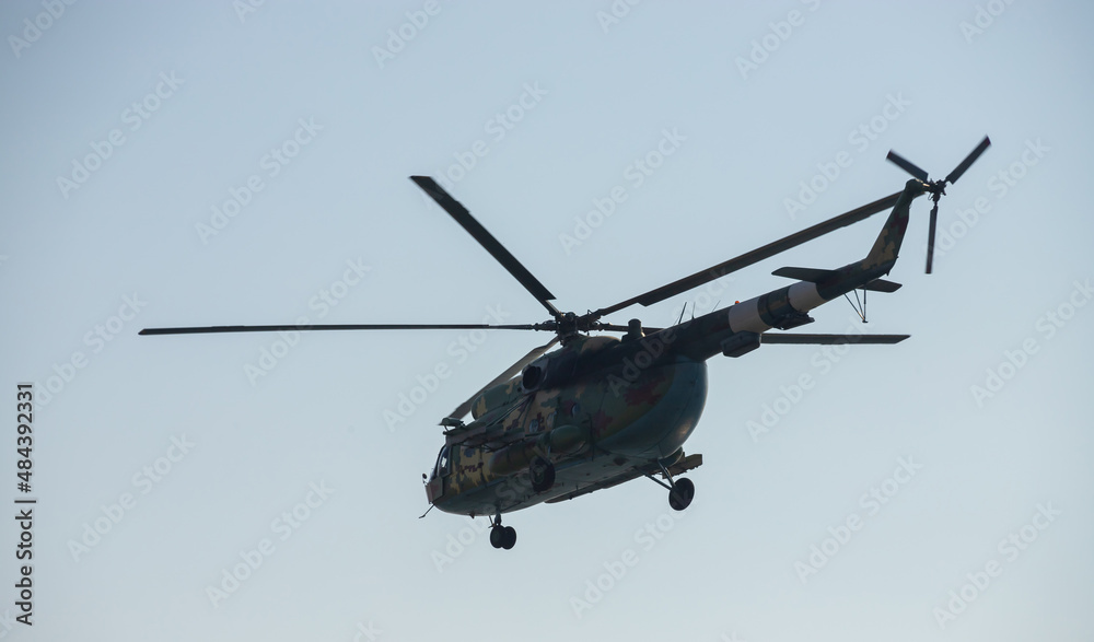 The military helicopter against the blue sky The military helicopter against the blue sky