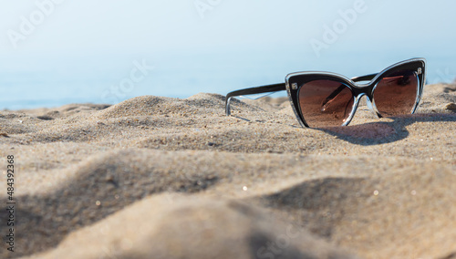 Sunglasses on the beach. Relaxation Vacation Travel - Blue Sea, White Sand, Shining Sun on the Beach