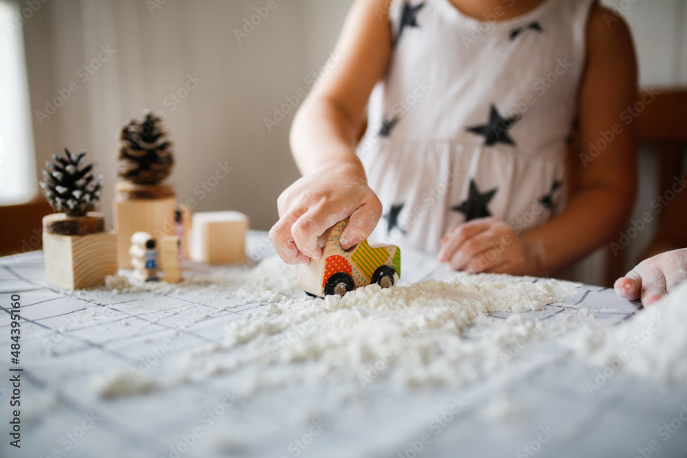 Funny children play with artificial snow at home in the kitchen. Educational classes and experiments with children at home. Sensory development and games at home. Snow from starch and shaving foam Funny children play with artificial snow at home in the kitchen. Educational classes and experiments with children at home. Sensory development and games at home. Snow from starch and shaving foam