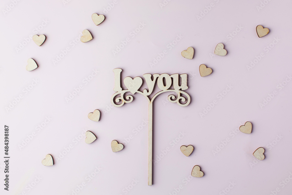 Fototapeta premium A wooden axe with the words I LOVE YOU on a pink background. 