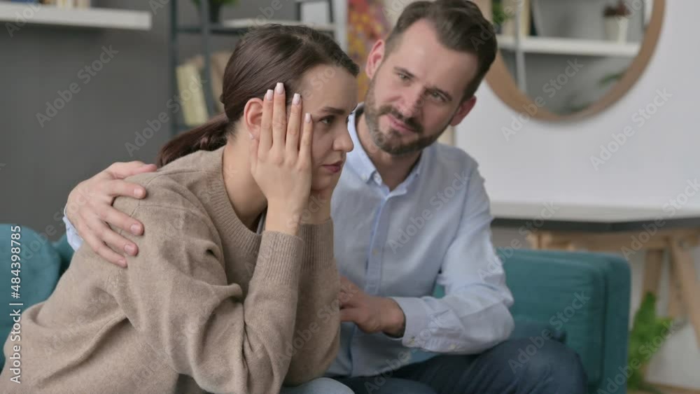 Man Trying to Comfort Upset Female Partner on Sofa Man Trying to Comfort Upset Female Partner on Sofa