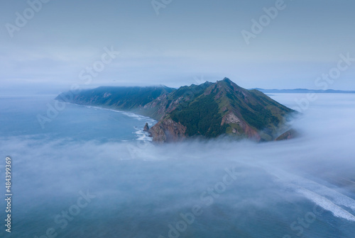 Morning Fog Going Through a Mountain Range in Tikhaya Bay, Sea of Okhotsk, Sakhalin Island, Russia photo