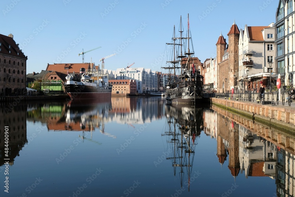 Panorama of Old Town and new buildings on Olowianka island in Gdansk. Motlawa canal with ships. Beautiful reflections in water. Poland Panorama of Old Town and new buildings on Olowianka island in Gdansk. Motlawa canal with ships. Beautiful reflections in water. Poland