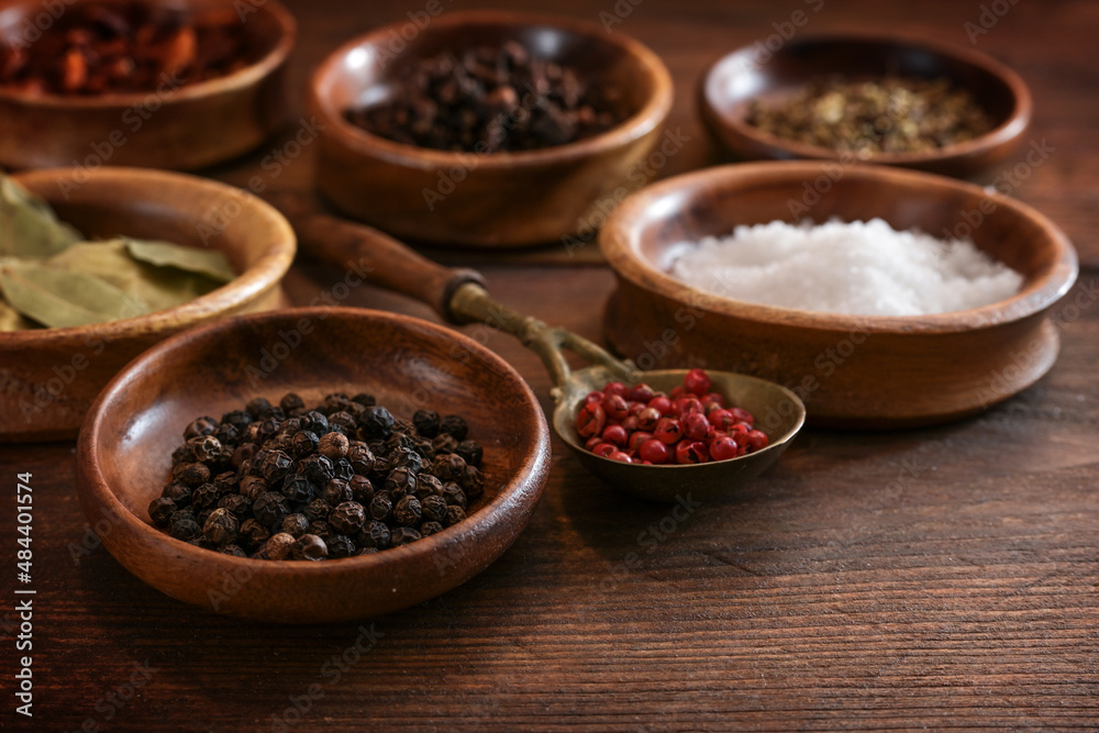 Various spices in small wooden bowls on a dark brown rustic table, food concept, selected focus Various spices in small wooden bowls on a dark brown rustic table, food concept, selected focus