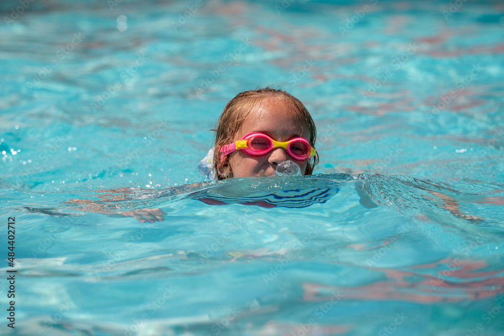 Naklejka premium Happy child girl playing in the sea. Kid having fun in water. Summer vacation and healthy lifestyle concept.