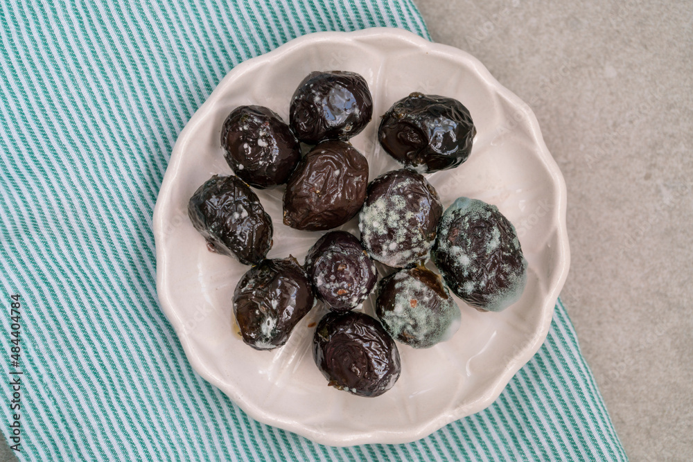 top view moldy inedible black olives on plate top view moldy inedible black olives on plate