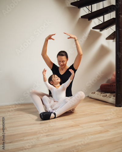 Young mother and 3 years old daughter dancing classical ballet at home