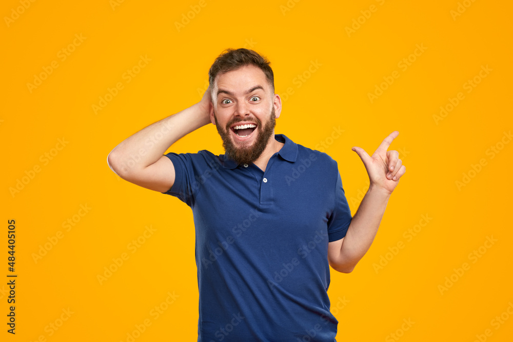 Amazed man pointing aside and touching head Amazed man pointing aside and touching head