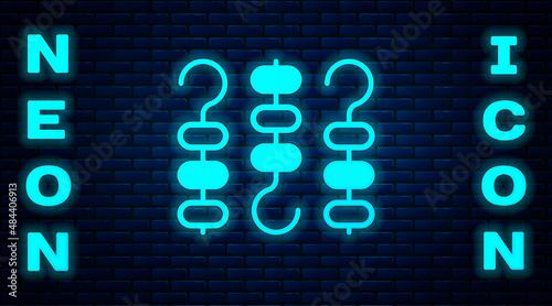 Glowing neon Grilled shish kebab on skewer stick icon isolated on brick wall background. Meat kebab on skewer stick. Picnic with grilled meat. Vector