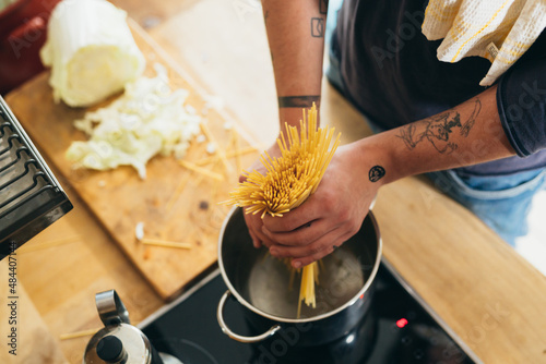 Obraz na plátně close up of man preparing pasta at home