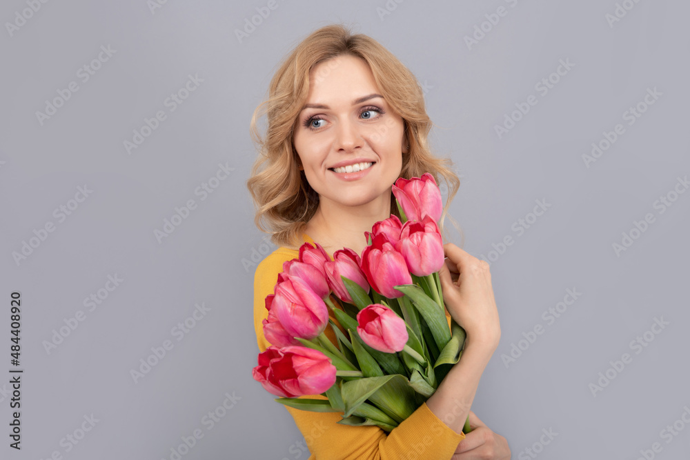 glad woman with tulips. lady hold flowers for spring holiday. girl with bouquet