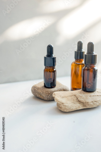 Glass dropper bottles with pipette on the stone. Cosmetic oil bottle mockup. Mockup scene. Product presentation concept.