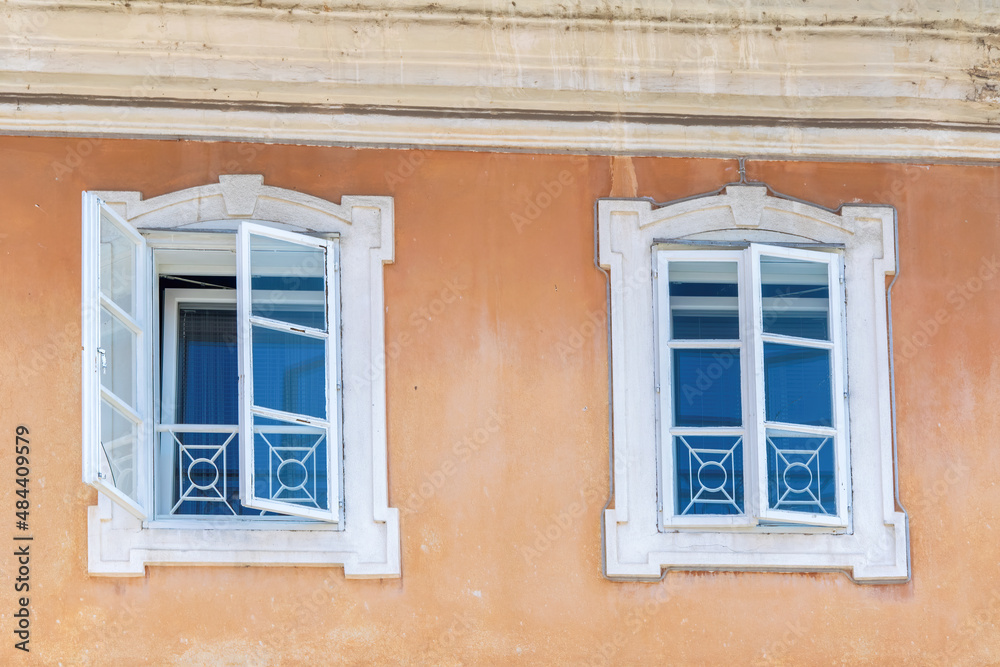 Two windows on the wall of old medieval house in the historic center of Kranj, Slovenia