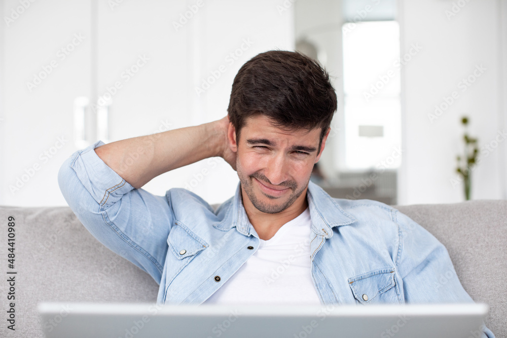 Front view headshot young pensive man looking at laptop screen.
