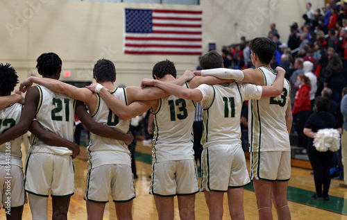 A basketball team stands during the National Anthem