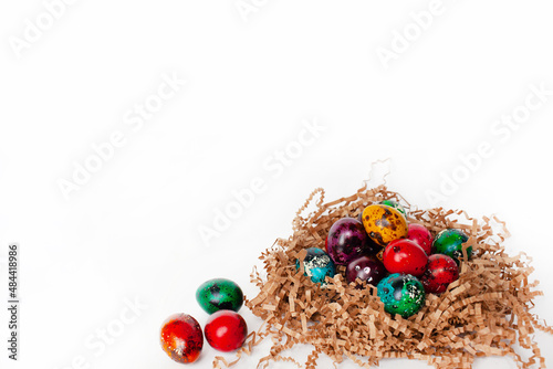 traditional Easter decoration. multicolored bright quail eggs in a nest on a white background. banner