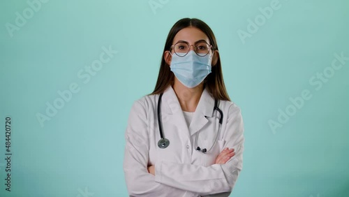 Portrait Of Smiling Caucasian Female Doctor Wear Face Mask Satisfied With Her Job In White Uniform And Stethoscope On A Blue Background Concept Of Medicine, Technology, Health Care And People Hospital