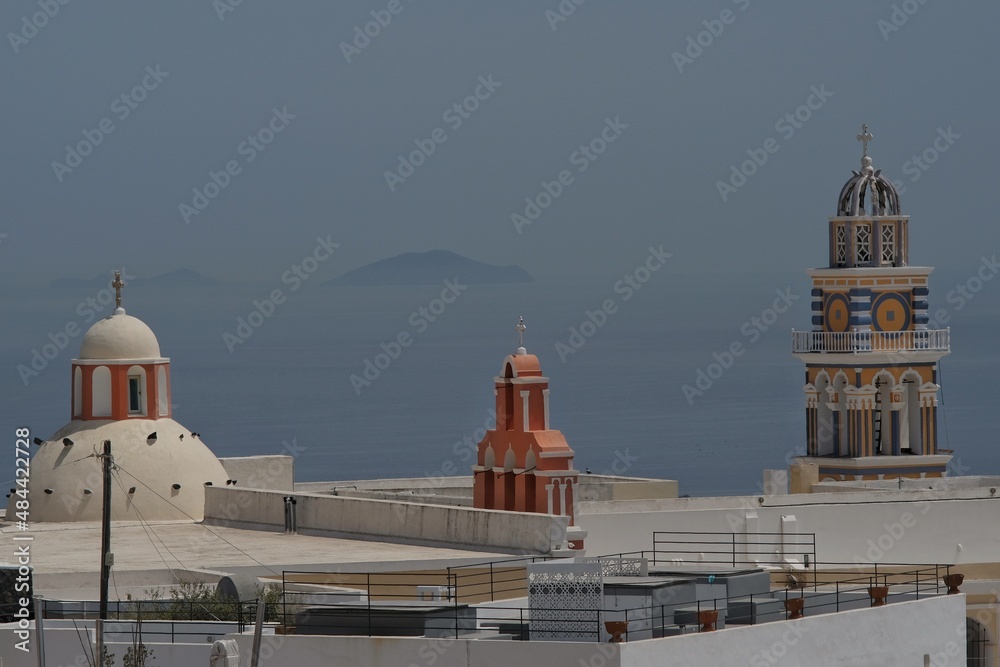 View of three orthodox churches in Santorini and the island of Anafi in the background