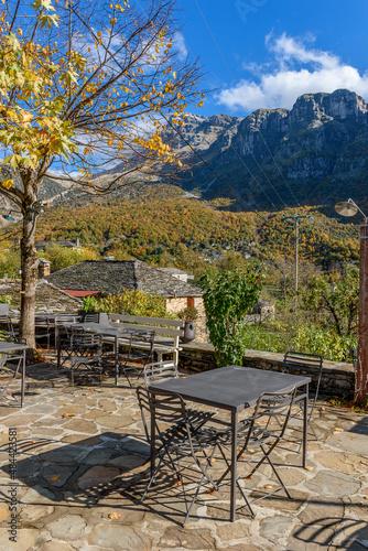 view of traditional architecture with stone buildings and background astraka mountain during fall season in the picturesque village of papigo , zagori Greece