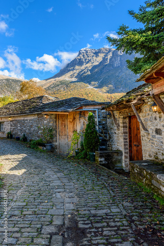 view of traditional architecture  with   stone buildings and background astraka mountain during  fall season in the picturesque village of papigo , zagori Greece photo