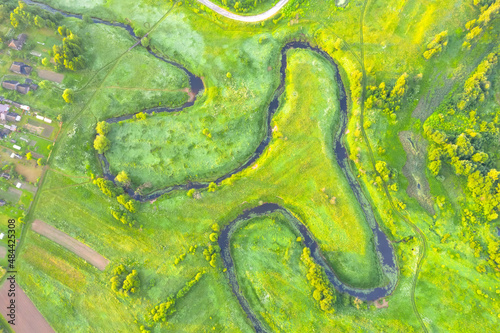 River meanders through national wildlife refuge, early summer aerial view.