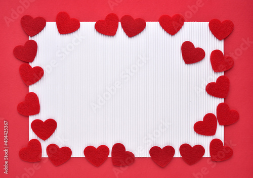 Felt hearts on red and white paper. Valentine's Day concept. Top view with copy space for text.