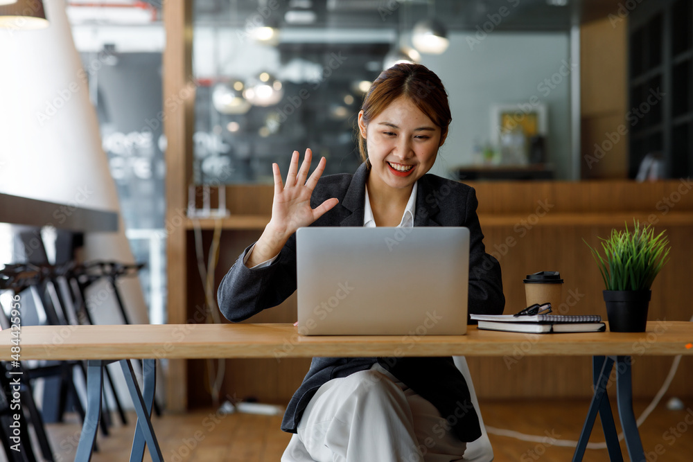 Shot of Asian young business woman looking and speaking through the webcam while making a video conference from the office.