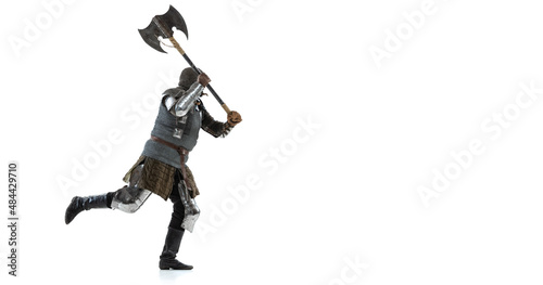 Full-length side view portrait of medieval warrior, knight running with battle ax isolated over white studio background