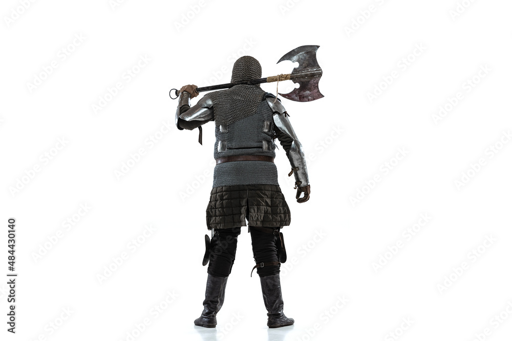 Portrait of brutal brave man in costume of medieval warrior, knight posing isolated over white studio background. Back view