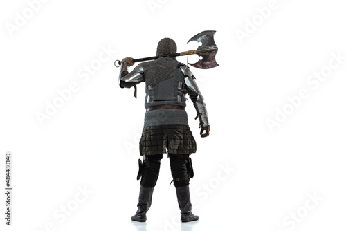 Portrait of brutal brave man in costume of medieval warrior, knight posing isolated over white studio background. Back view