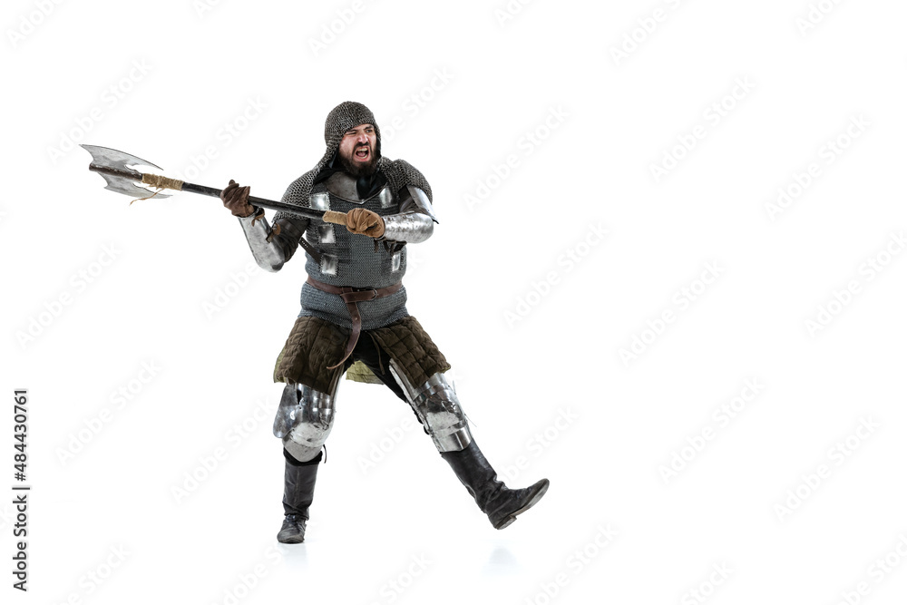 Full-length portrait of brutal serious man, medieval knight swinging ax, ready to figth isolated over white studio background