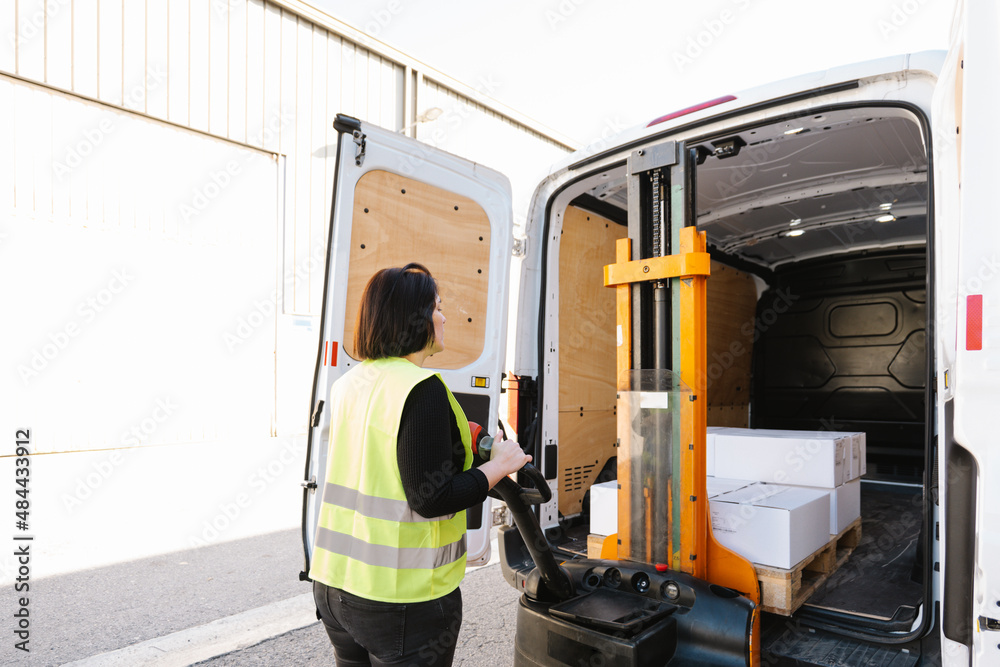Anonymous woman loading boxes with stacker Stock Photo | Adobe Stock