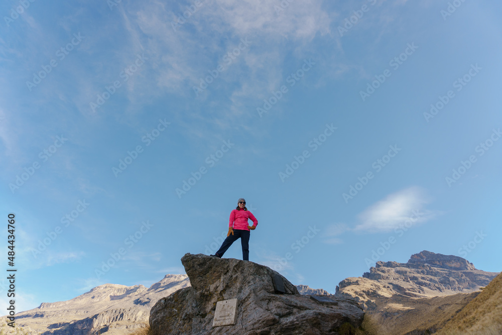 woman hiker at mountain top cliff edge