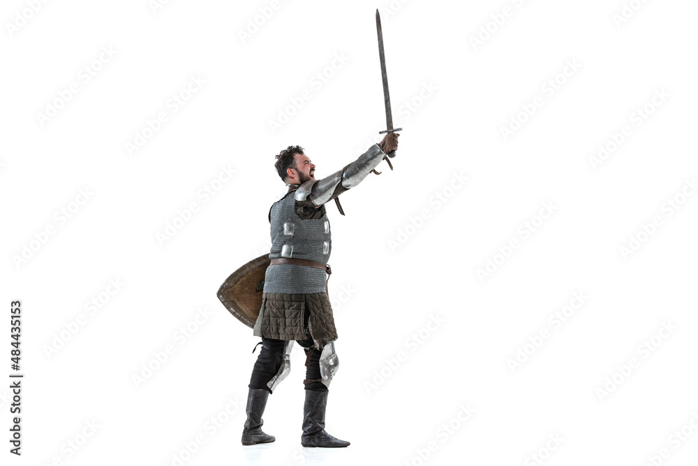 Dynamic portrait of seriuos man, medieval warrior or knight with dirty wounded face holding sword isolated over white background. Dynamic portrait of seriuos man, medieval warrior or knight with dirty wounded face holding sword isolated over white background.