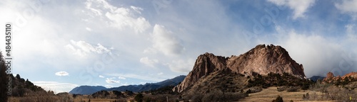 Panorama of a massive rock outcropping before a ridge of the Rocky Mountains, Colorado American west with dramatic clouds, horizontal aspect