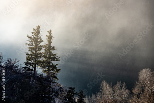 Sun rays streaking through mountain fog