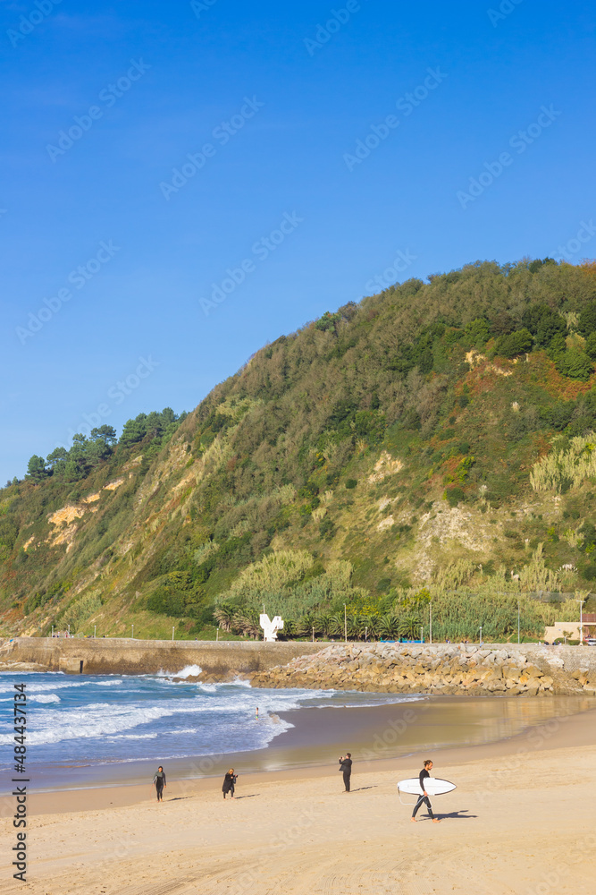 Fototapeta premium Surfer with surfboard walking on the Zurriola beach in San Sebastian