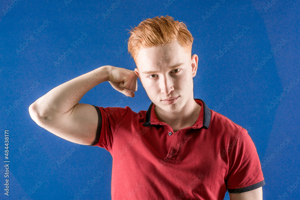 A successful smiling male model happily raises her hands. A confident red-haired muscular man, shows muscles on his arms, is proud that he is strong and has strength. Sportsman A successful smiling male model happily raises her hands. A confident red-haired muscular man, shows muscles on his arms, is proud that he is strong and has strength. Sportsman
