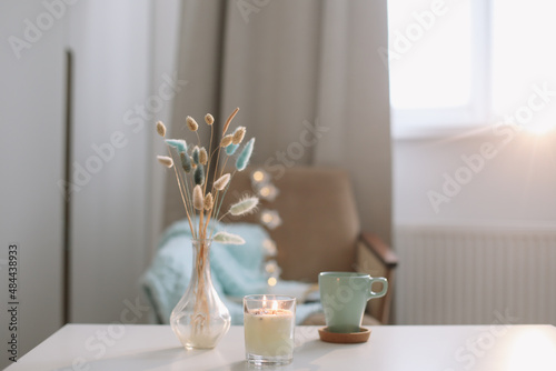 Cup of coffee and a vase with flowers in a cozy room