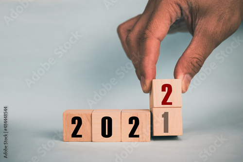 Hand hold wooden cubes 2021 and 2022 concept business change to new success