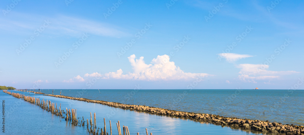 Landscape photo of sea or ocean with blue sky and white clouds.