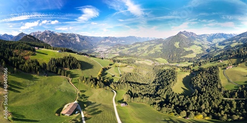 Fototapeta Naklejka Na Ścianę i Meble -  Aerial panorama of an alpine summer landscape with green woods and mountain meadows. Drone shot of little farms and villages. Hiking vacation at Alpbach and Inntal valley in Tyrol, Austria.