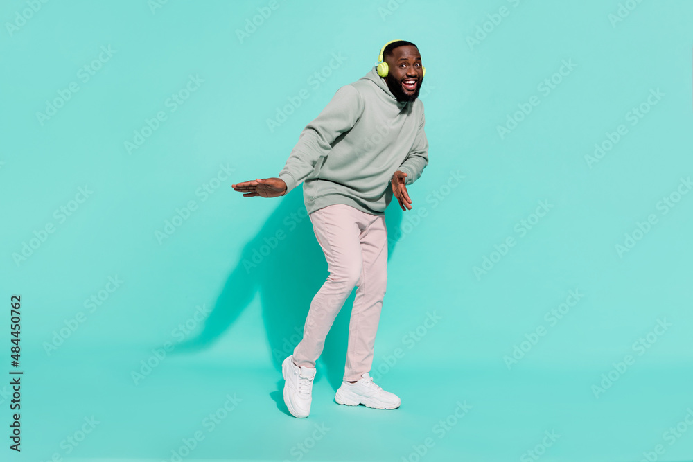 Full length body size view of cheerful attractive guy dancing hip hop rest chill out isolated over shine teal turquoise color background Full length body size view of cheerful attractive guy dancing hip hop rest chill out isolated over shine teal turquoise color background
