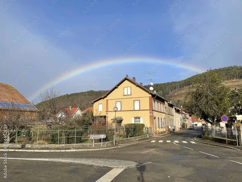 Village (Buhl, Alsace, France) in the forest mountains with a rainbow